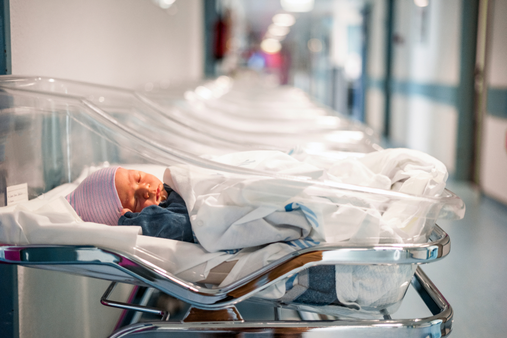 A baby laying in a hospital bed after birth 
