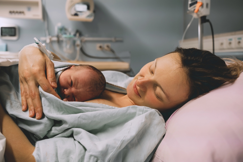 A mother holding her new born baby in the hospital after giving birth