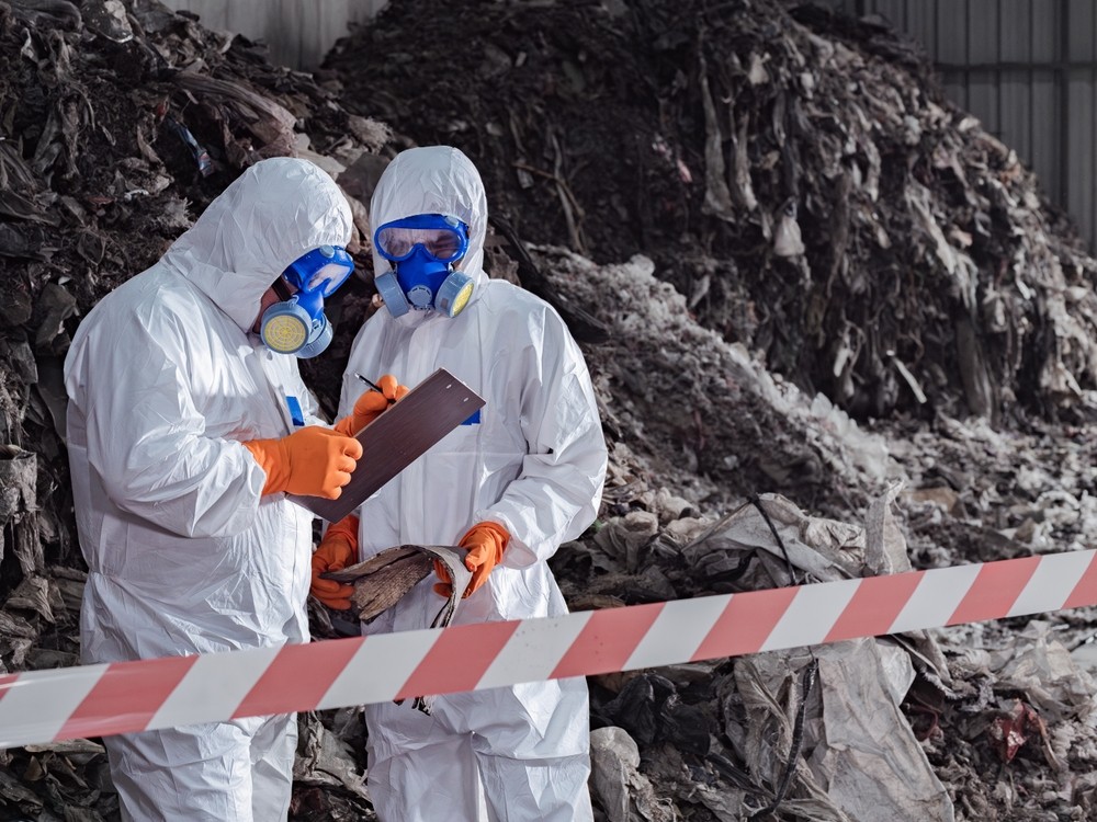 Protective-suit inspectors document suspected asbestos materials for mesothelioma lawyers.